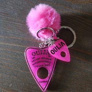 Hot pink ouija planchette with pom pom keychain